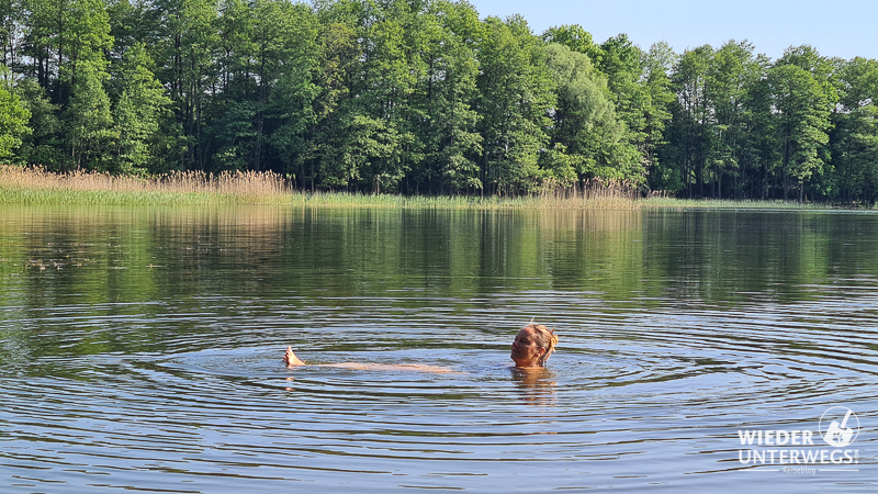 frau badet im see masuren camping