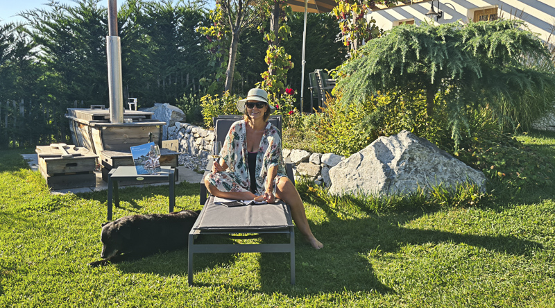 frau mit hund in eingezäuntem garten ferienhaus chalet winzerstöckl kittenberger kamptal i