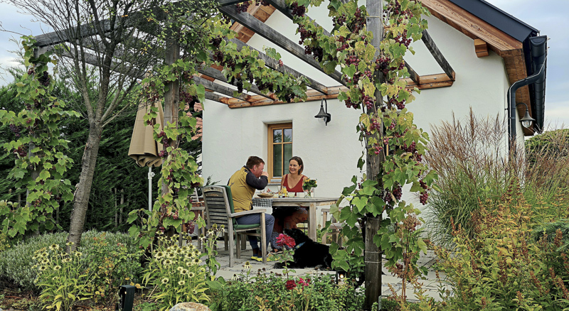 mit hund auf der terrasse winzerstöckl kittenberger chalets mit eingezäuntem privatgarten